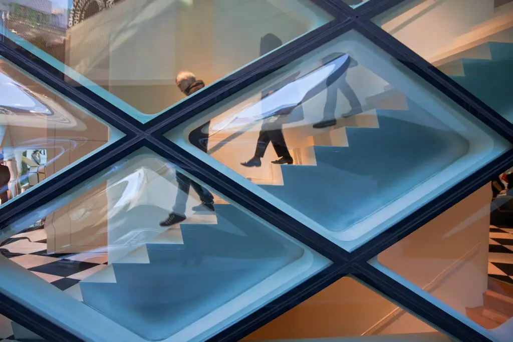 People walking down stairs through obscured glass