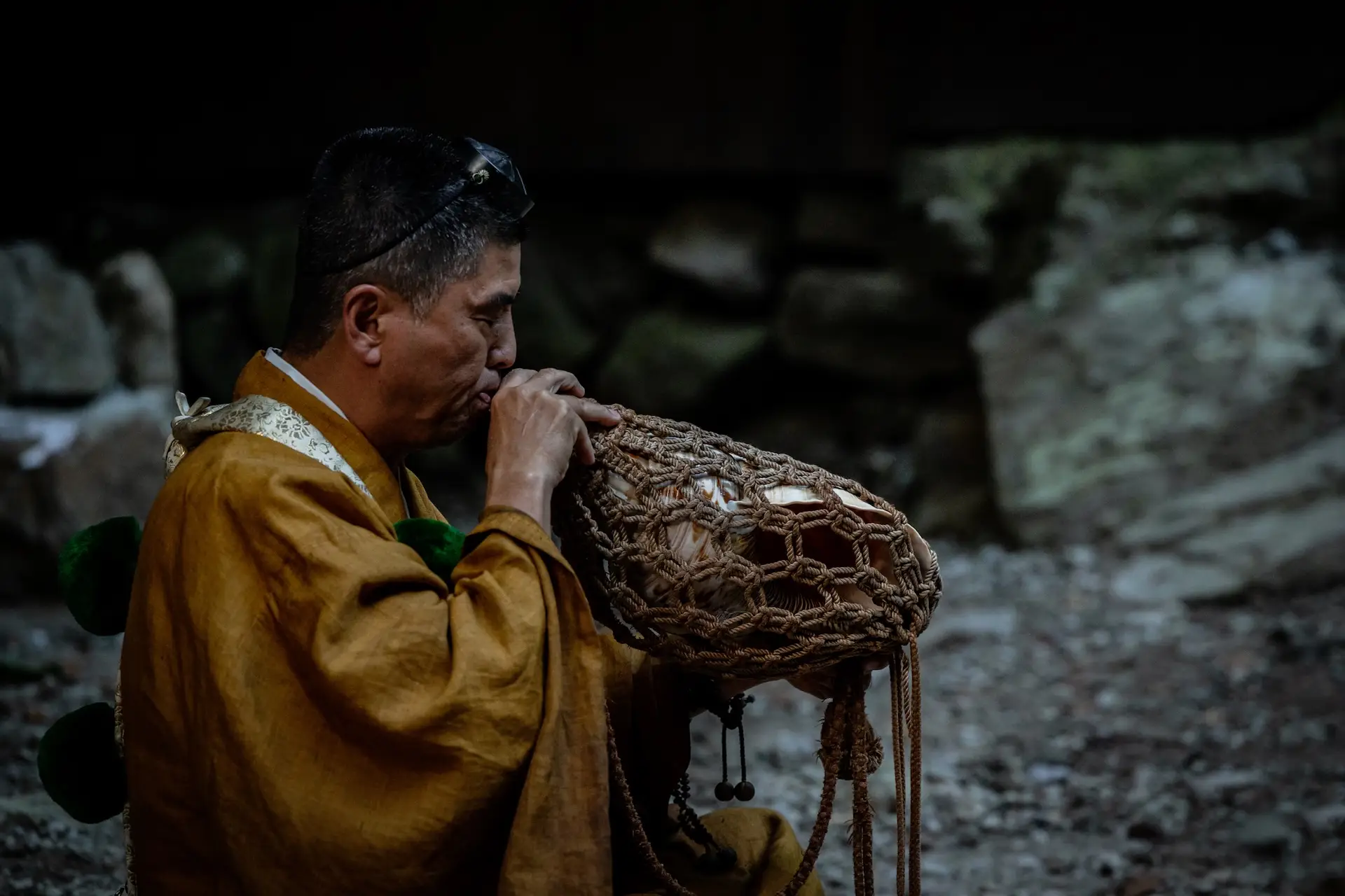 man blowing into a musical instrument